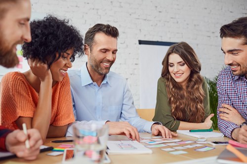 Group of men and women sit around table planning a project