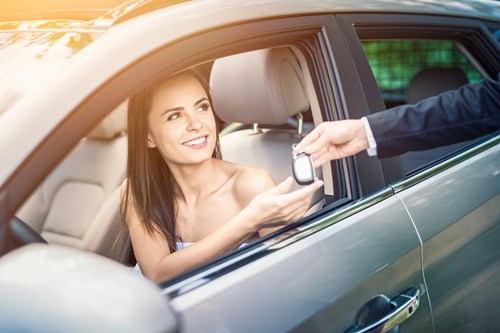 Woman reaches out of car window to take car keys from business man