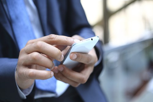 Business man in suit uses smartphone