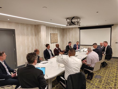 Businessmen and women around a table discuss