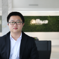 Business man in a white shirt and black suit jacket wearing black-rimmed glasses