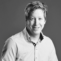 Black and white headshot of a business pan with a pale shirt.