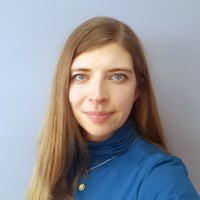 Businesswoman in blue turtleneck with long brown hair