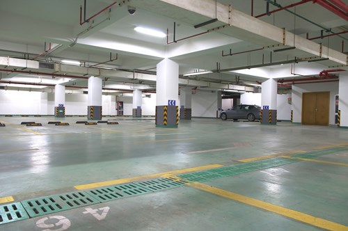 A parking garage with green bays.