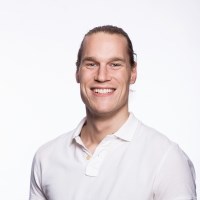 Businessman with hair tied back wearing a white polo shirt