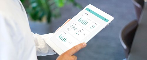 Woman holding a tablet displaying the Autopay Dashboard