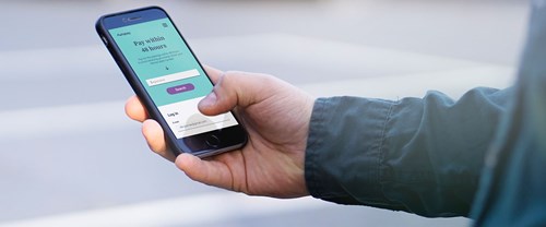 Man holding smartphone displaying Autopay app