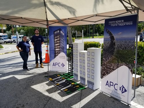 Man and Woman from APC stand at parking space installation