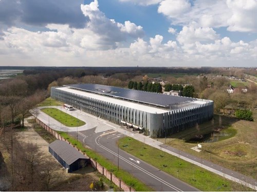 Parking garage with bus parked outside surrounded by forest and fields