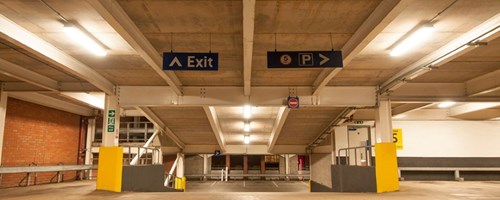 Well lit parking garage showing ramp between two floors