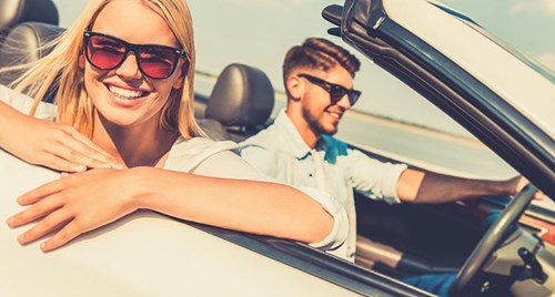 Man and woman in a convertible car