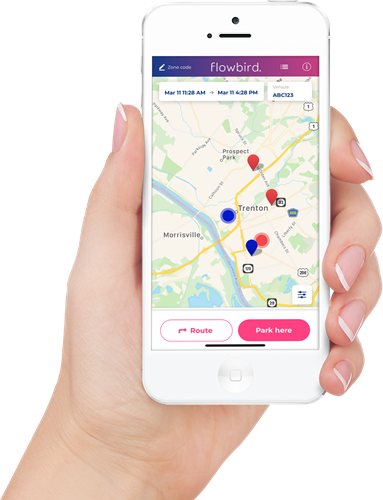 Hand holds a white smartphone displaying a map of Trenton with parking locations marked