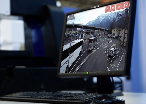 CCTV footage of a coach parking lot with snowcapped moutains in the background