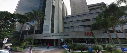 High-rise grey office building with trees in front