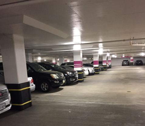 Cars parked in a garage, pillars protected by black cladding