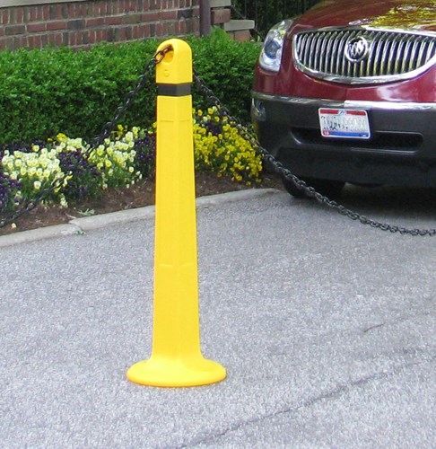 Yellow post with chain and red car