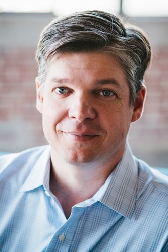 Portrait photo of a man with blue shirt looking at the camera