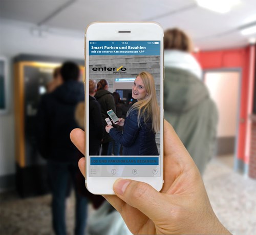 Person uses smartphone to take photo of woman using a parking machine 